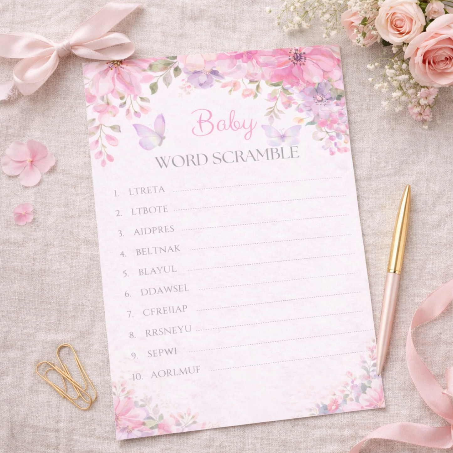 Baby word scramble game sheet with floral design on a textured surface with flowers and ribbons.