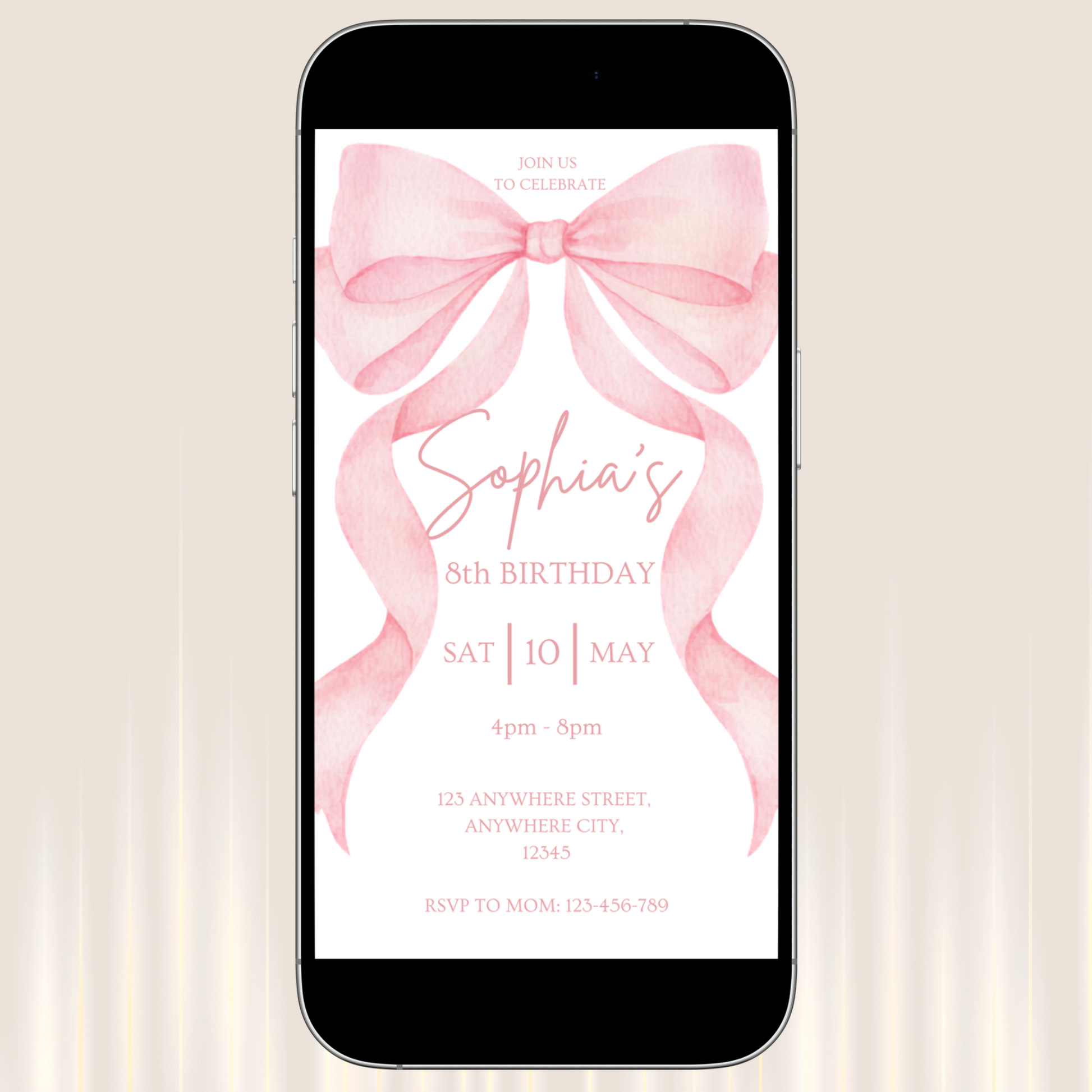 Phone displaying a birthday invitation with a pink bow on a beige background