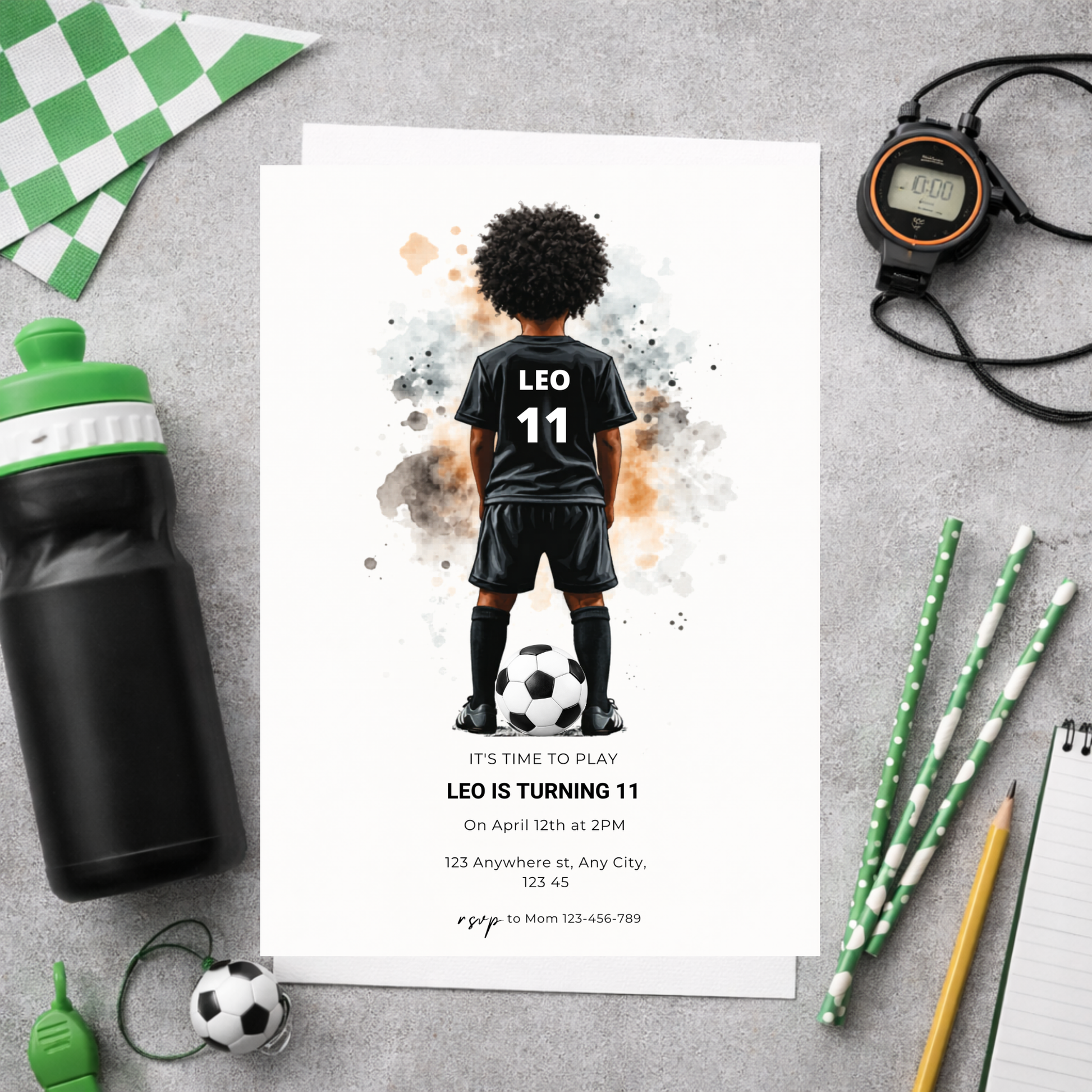 Birthday invitation card with soccer-themed design on a gray surface with party supplies.