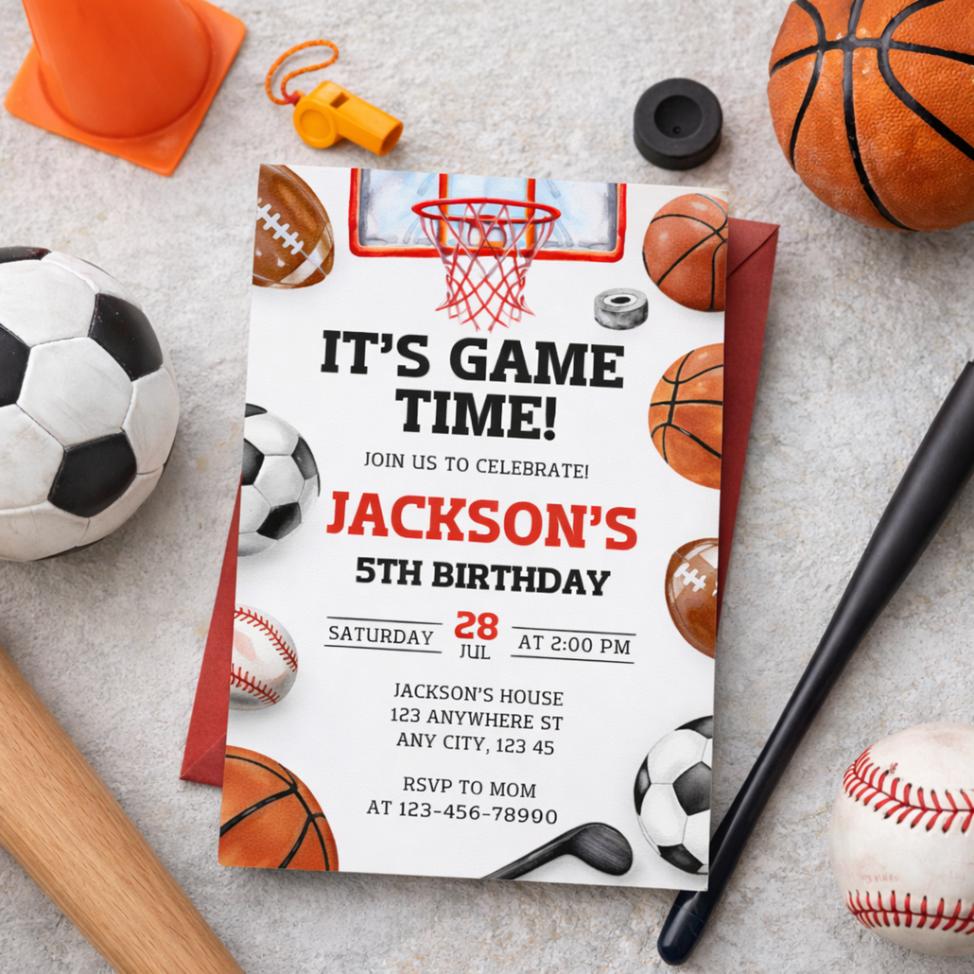Birthday invitation card with sports-themed decorations on a gray surface with sports equipment.