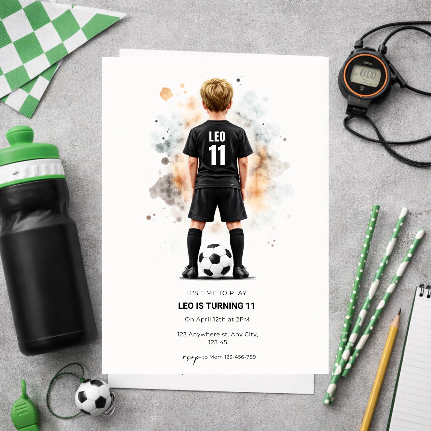Birthday invitation card with soccer theme on a gray surface with party supplies.