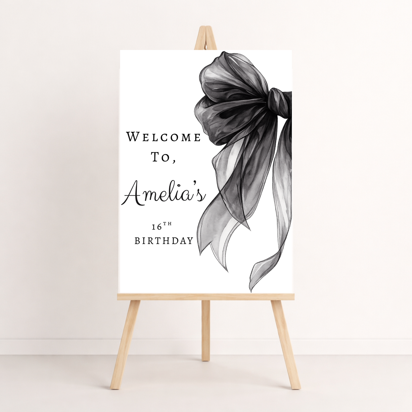 Decorative sign with a black bow and text on an easel against a white background