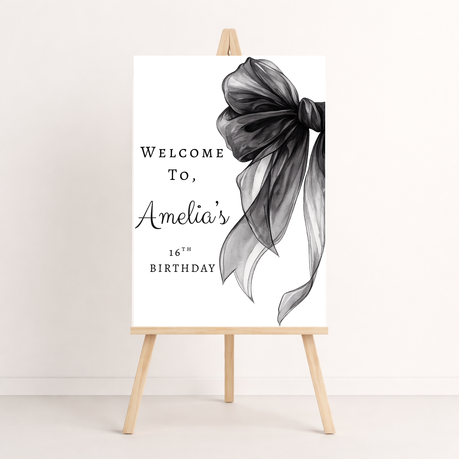 Decorative sign with a black bow and text on an easel against a white background