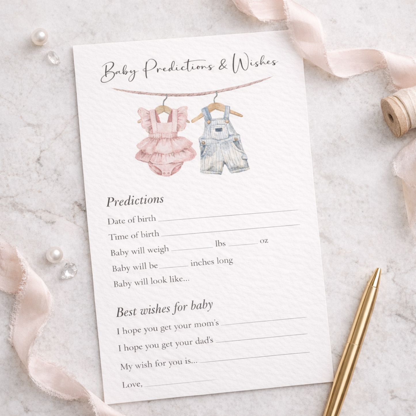 Baby predictions and wishes card with illustrations of a pink romper and denim overalls on a marble surface.